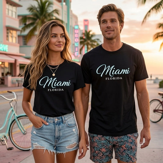 Two people wearing 'Miami Florida' t-shirts on a street with palm trees and buildings in the background.