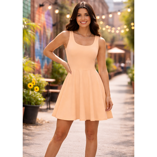 Woman in a peach dress standing outdoors with plants and buildings in the background
