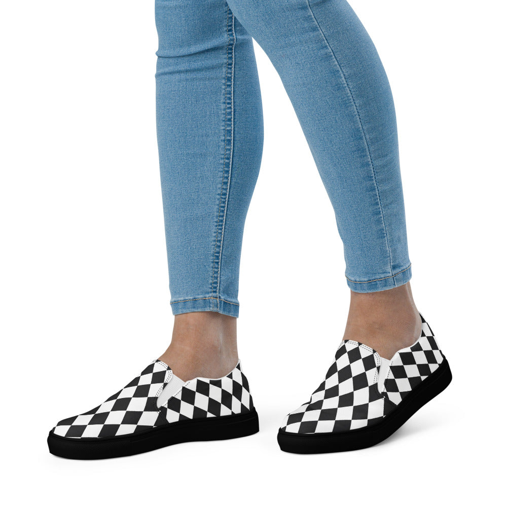 Black and white checkered shoes worn with blue jeans on a white background